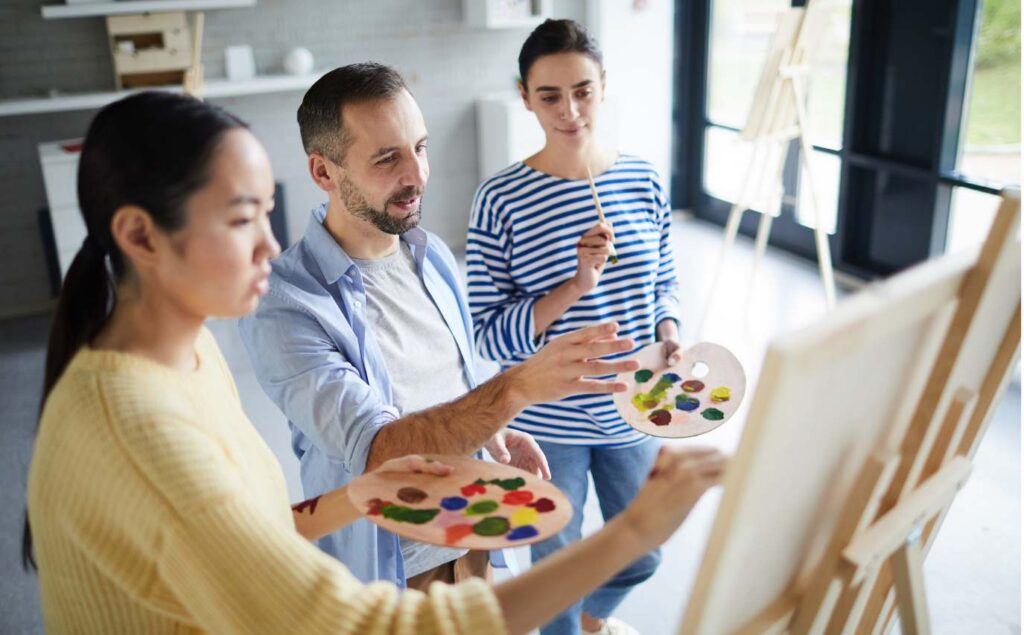 Individuals painting together during an art therapy session.