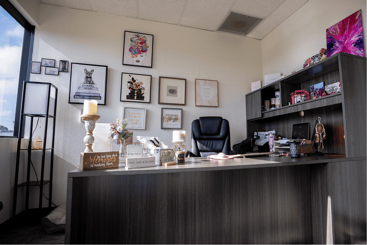 Modern office reception with artwork, desk, and comfortable chair at Assure Recovery.