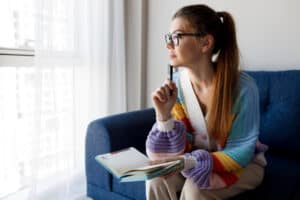 Woman taking notes at home while receiving support from a La Mesa rehab program at Assure Recovery Center.