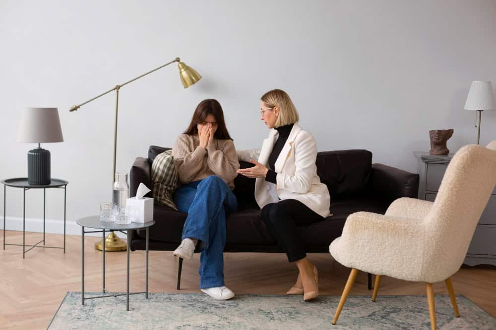 Distressed young woman speaking with a therapist about kratom addiction and withdrawal.
